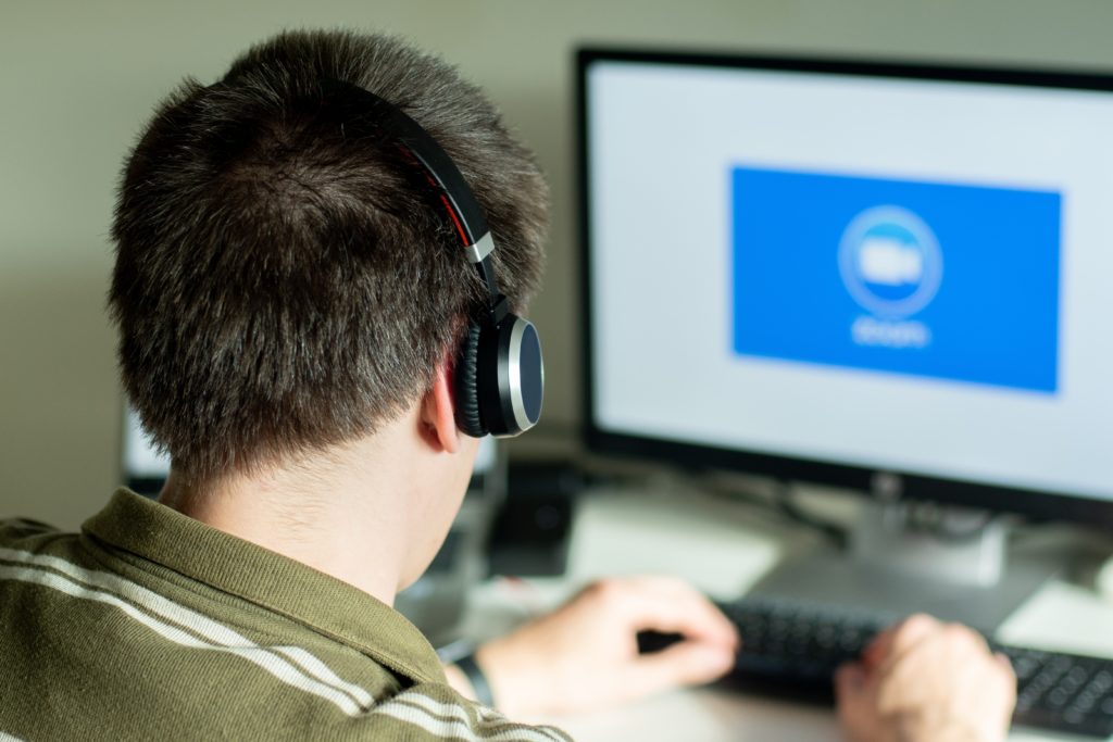 Man With Headphones Looking at Monitor